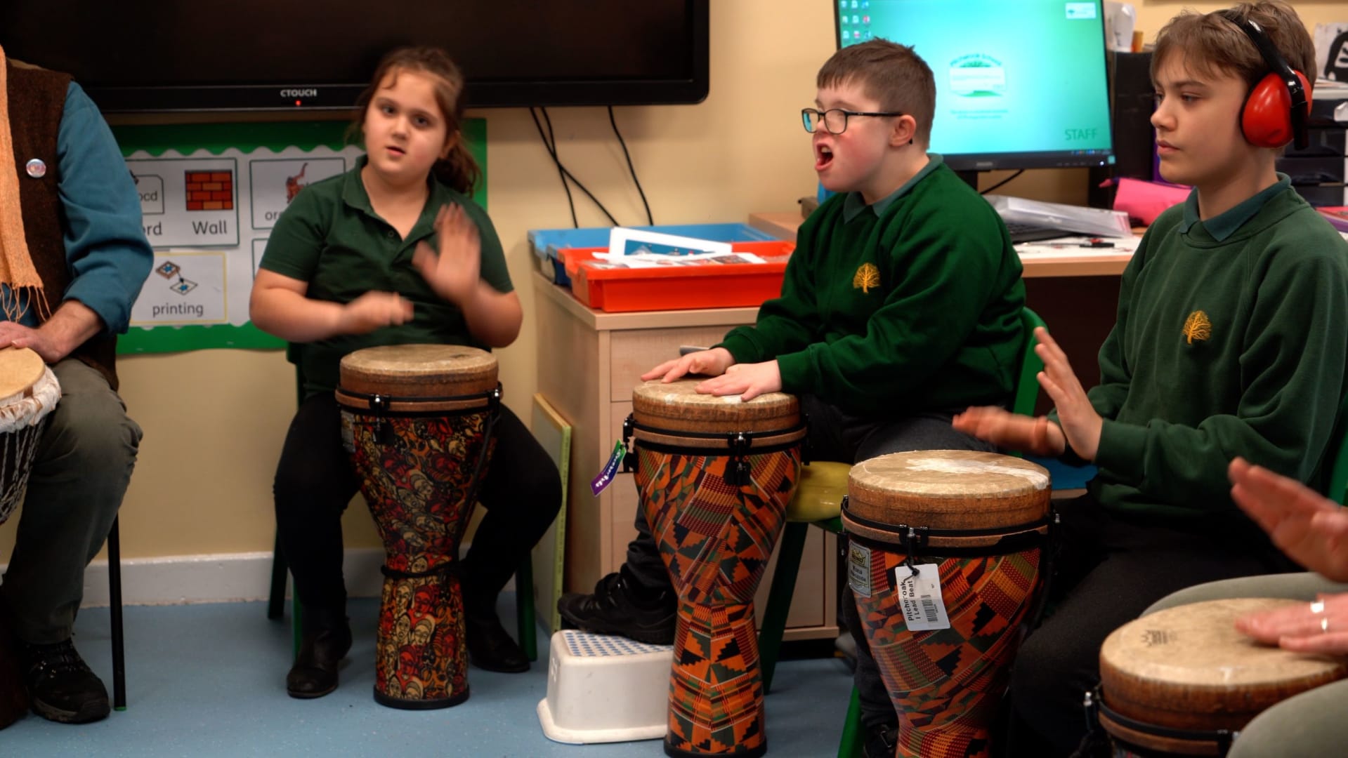 three young students drumming in a workshop